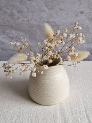 Gros plan sur le vase Achille contenant un bouquet de fleurs séchées