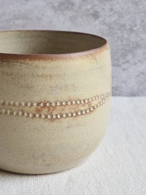 Détail du cache-pot beige argile avec effet de métal vieilli