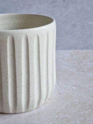 Détail du cache-pot cannelé de coloris blanc moucheté avec son décor de traits gravés à la main