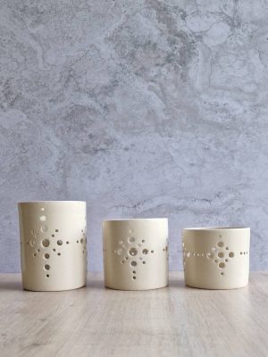 Trois photophores Antarès alignés, en grès émaillé écru et dans des tailles différentes