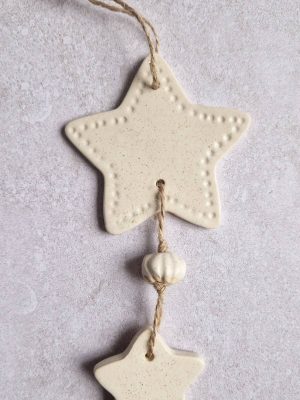 Détail de la suspension murale Céleste avec l'étoile et une perle modelée à la main
